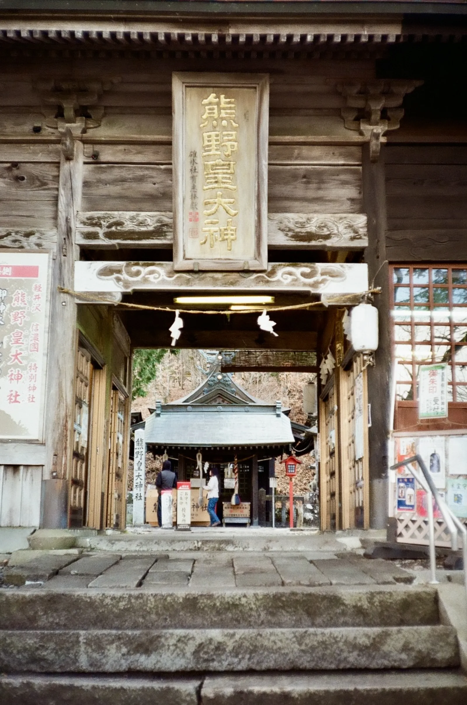 The wooden gate of Kumano Kotai shrine with a carved sign above the entrance