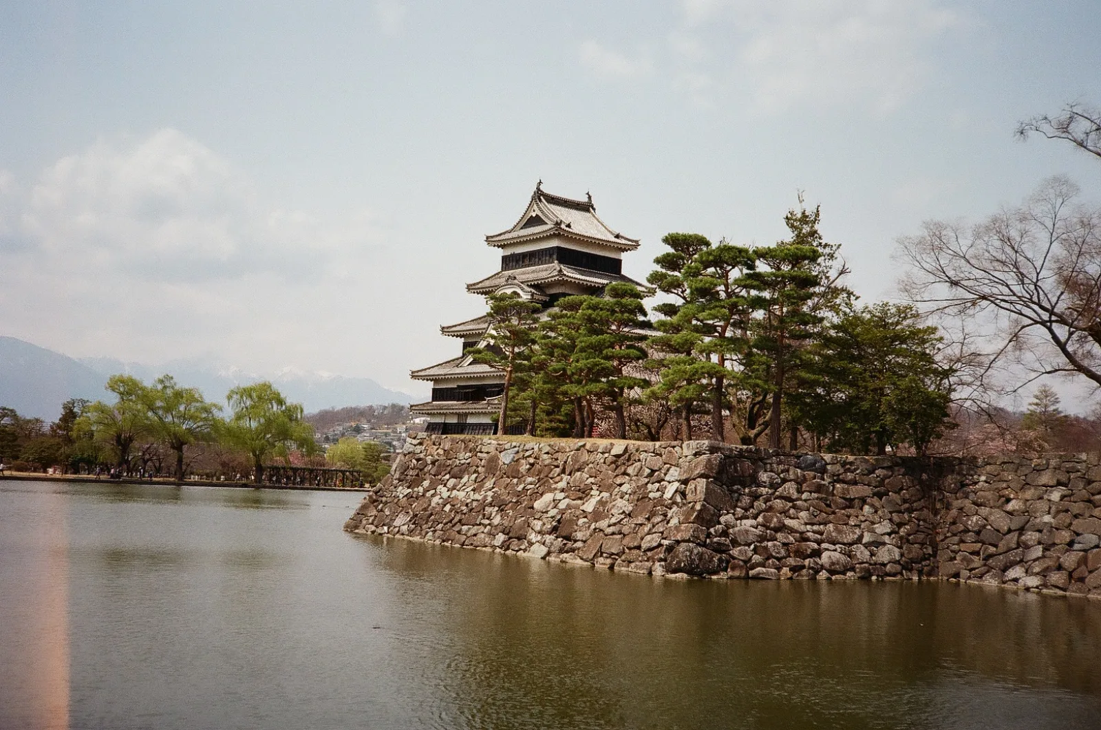 Matsumoto Castle, a black wooden keep on stone walls, seen across its moat
