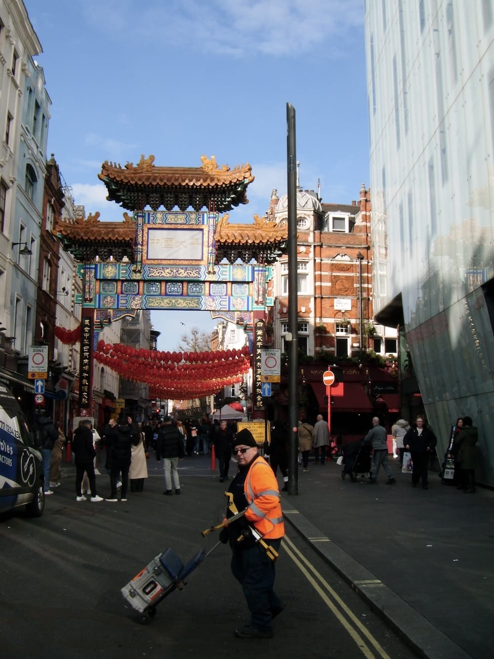 The ornate Chinatown gate on Wardour Street, with red lanterns strung across the road
