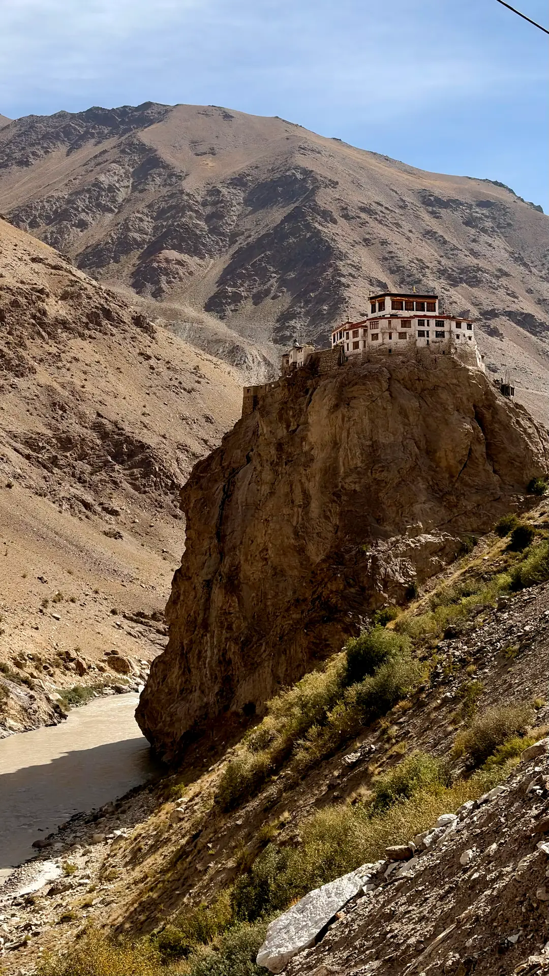 A monastery perched on a sheer rock outcrop above the river, on the road south of Padum
