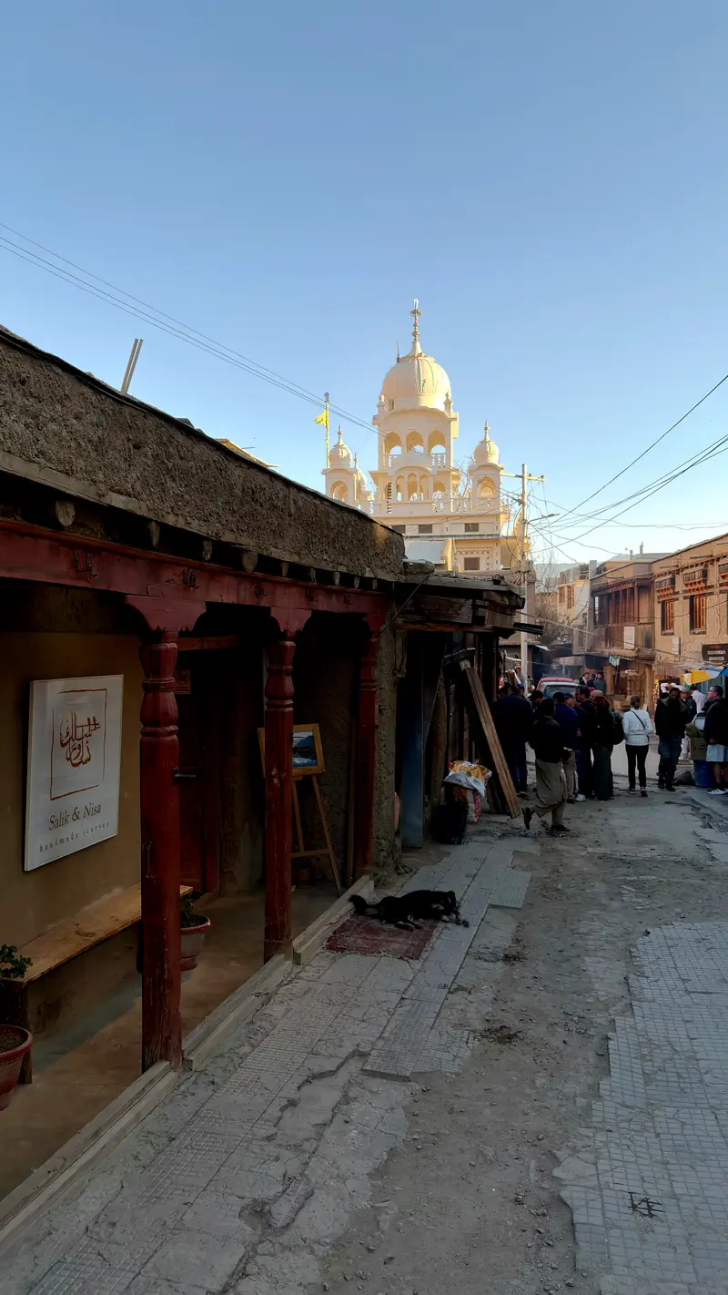 A bazaar street in Leh ending at the golden dome of a gurdwara