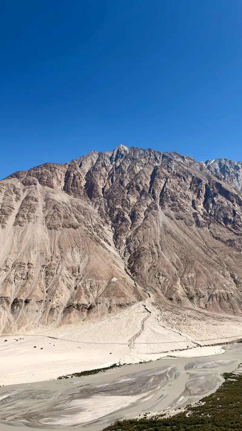 A vast scree mountainside above the braided channels of the river in the Nubra Valley
