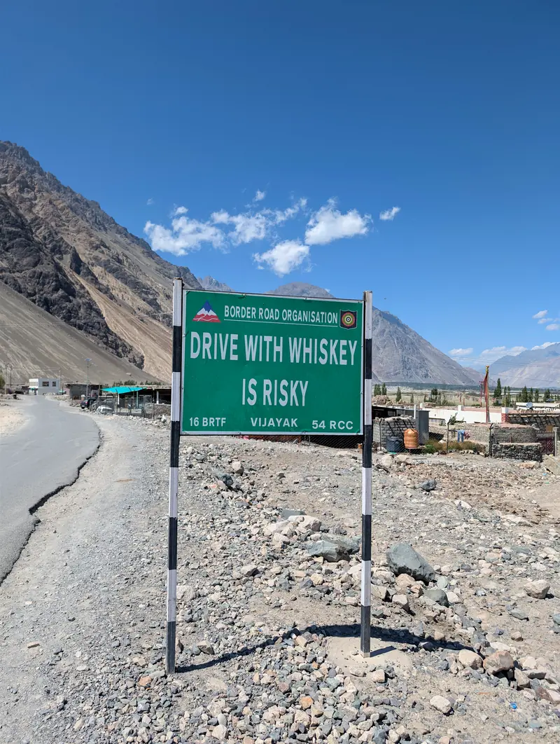 Green road sign reading: Drive with whiskey is risky