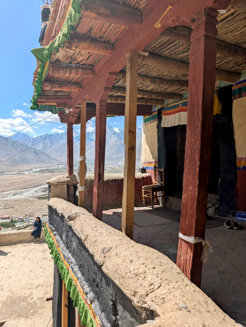 A carved wooden monastery balcony high above the Zanskar valley floor