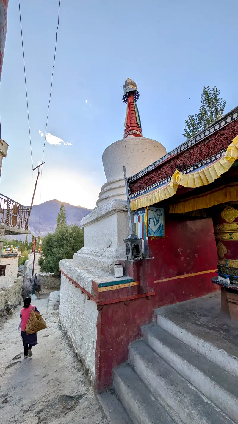 A villager walks past a whitewashed chorten in Sumur village at dusk